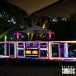 DJ Booths, Holograms & Lighting (3) A DJ host using a DJ booth outside with holograms