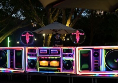 DJ Booths, Holograms & Lighting (3) A DJ host using a DJ booth outside with holograms