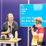 SILENT CONFERENCE HIRE (1) Two people at a conference showing the audience their products wearing Silent Sounds Headphones and using Silent Sounds microphones