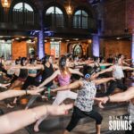 SILENT YOGA & FITNESS HIRE (1) A Yoga event with a group of people wearing Silent Sounds Headphones inside.