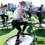 SILENT YOGA & FITNESS HIRE (3) A group of people doing a fitness event outside wearing Silent Sounds Headphones