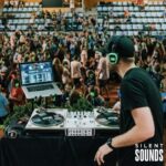STAFFED EVENTS HIRE (3) A DJ host playing music at an event wearing Silent Sounds Headphones.